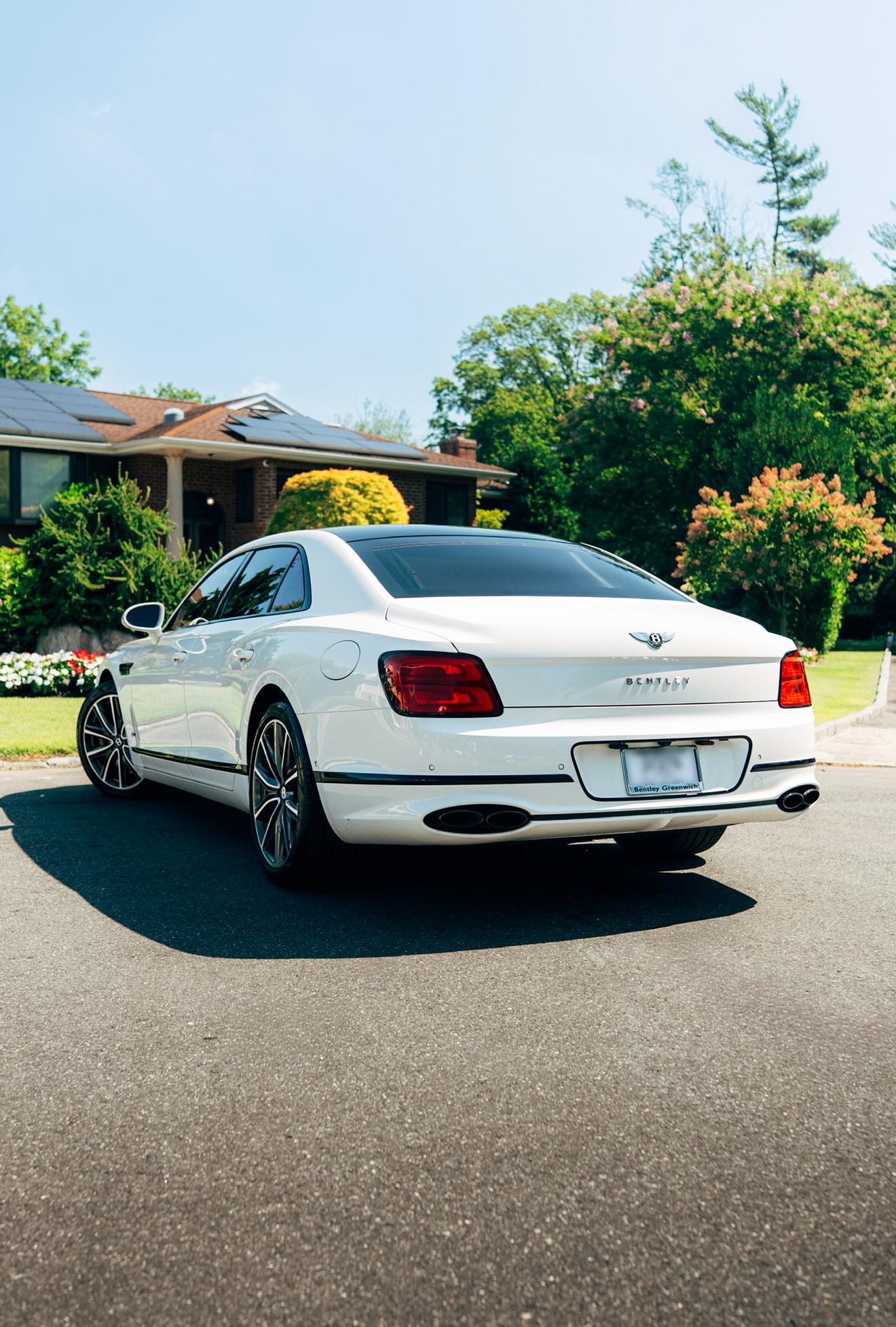 White Bentley Flying Spur shown from the rear three-quarter angle