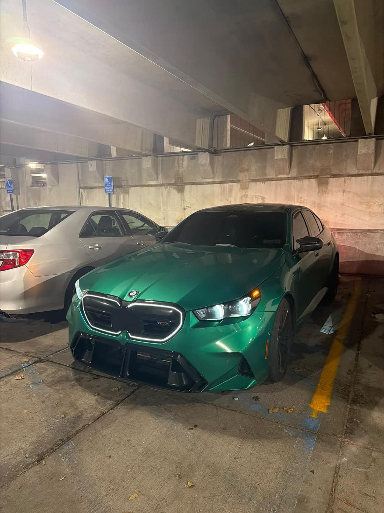 Green BMW M5 G90 shown from the front three-quarter angle