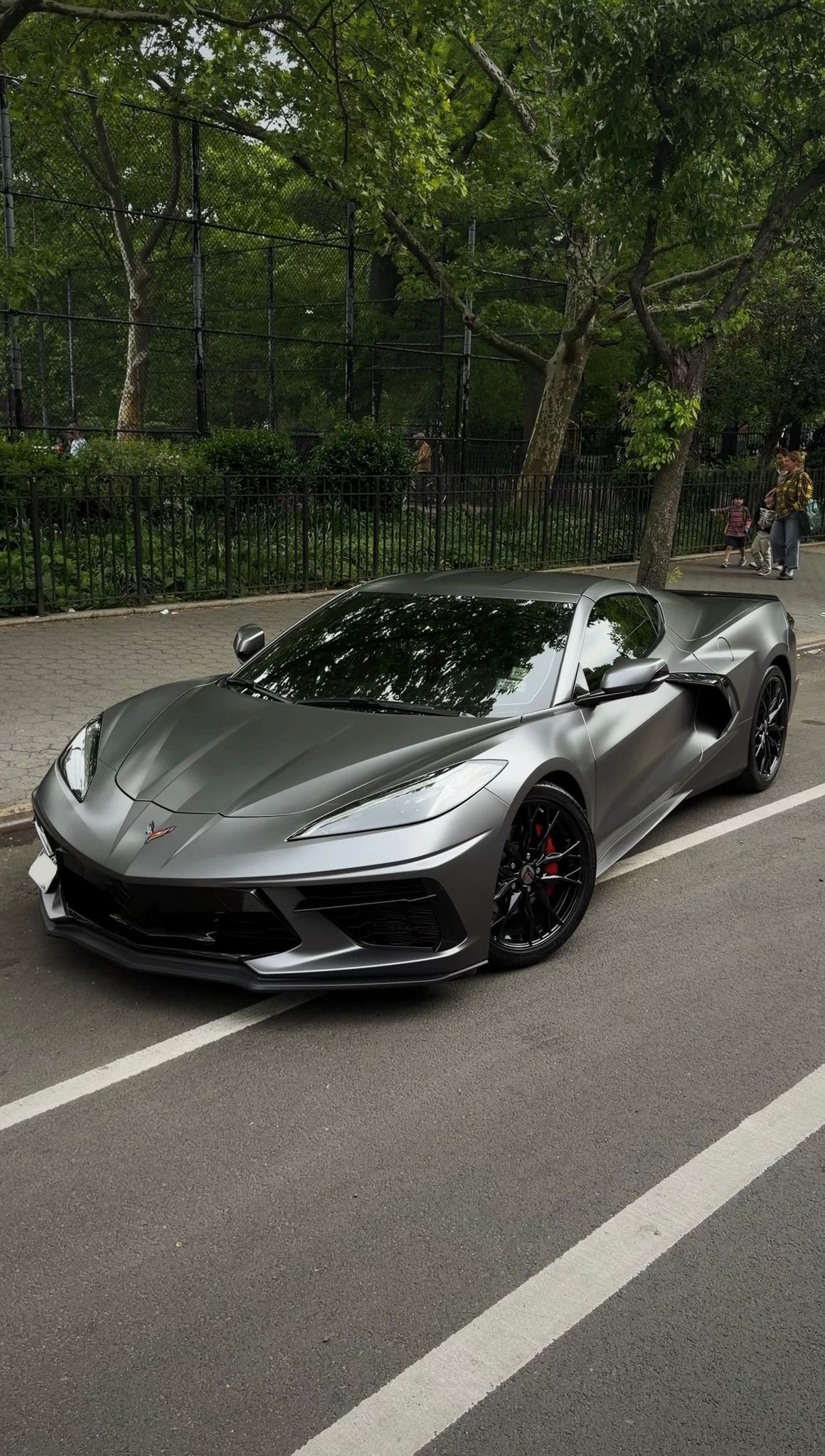 Matte gray Chevrolet Corvette C8 shown from the front three-quarter angle on a New York City street