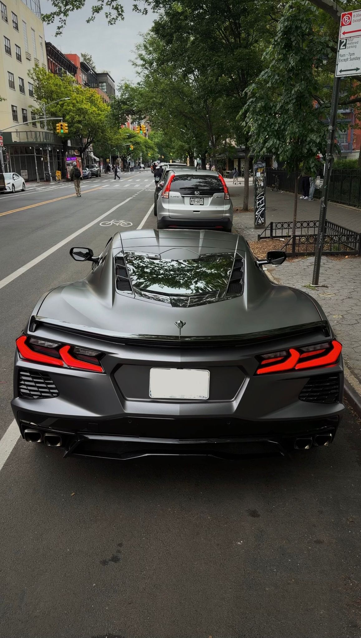 Matte gray Chevrolet Corvette C8 shown from the rear on a New York City street