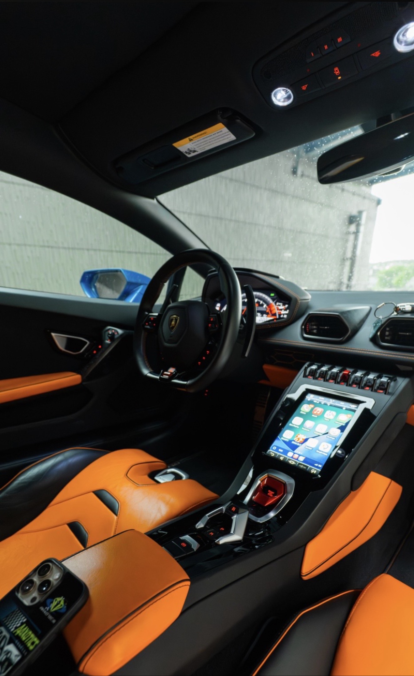 Driver cockpit and center console of the Lamborghini Huracán Evo with orange and black interior