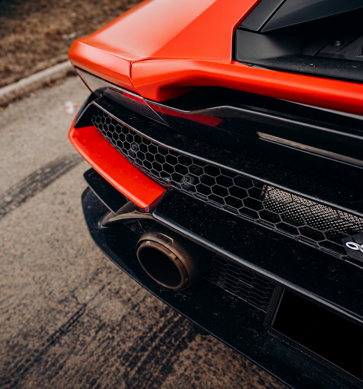 Rear exhaust and honeycomb grille detail of the red Lamborghini Huracán Evo