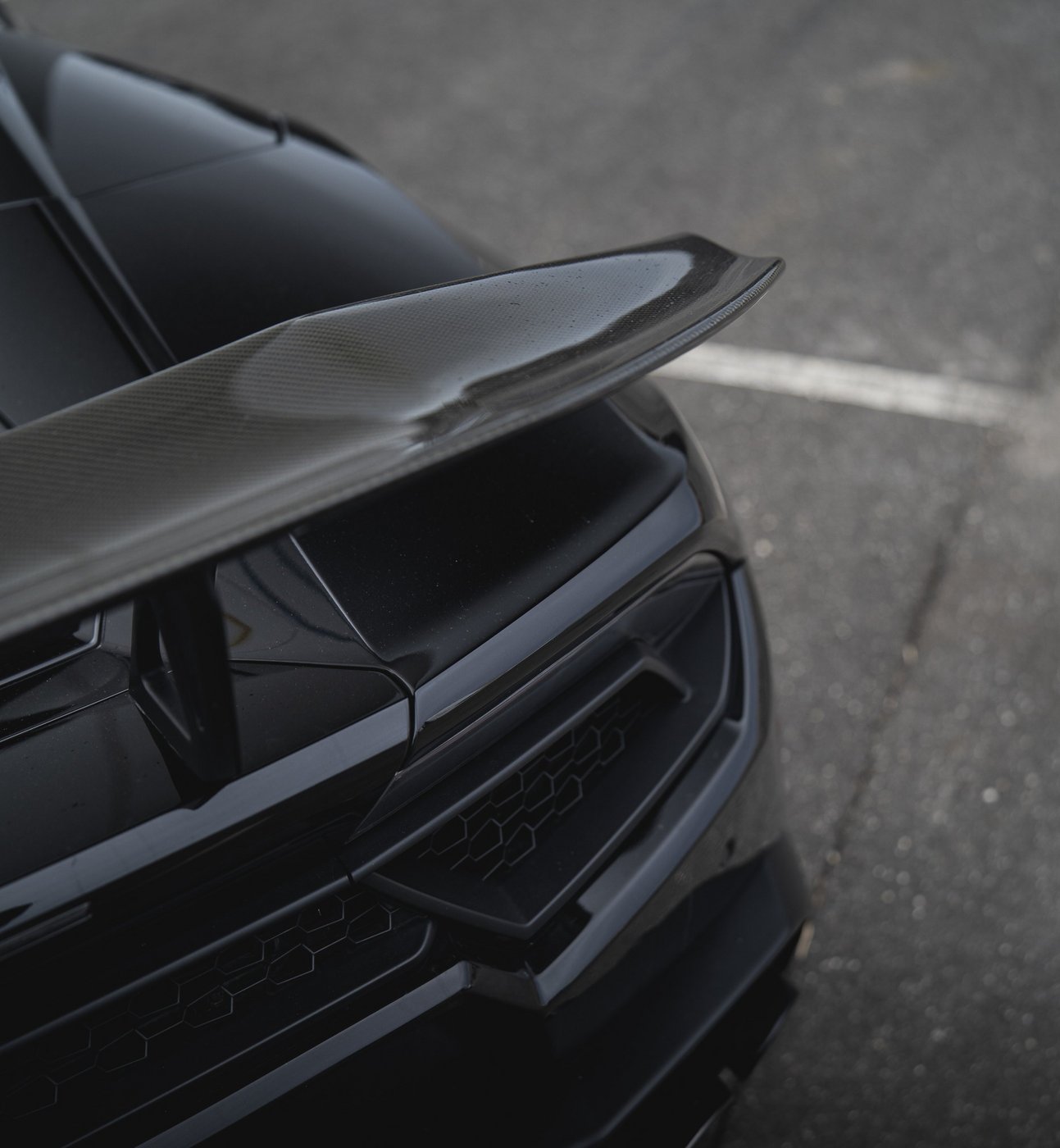 Carbon-fiber rear wing detail of the black Lamborghini Huracán Evo Spyder