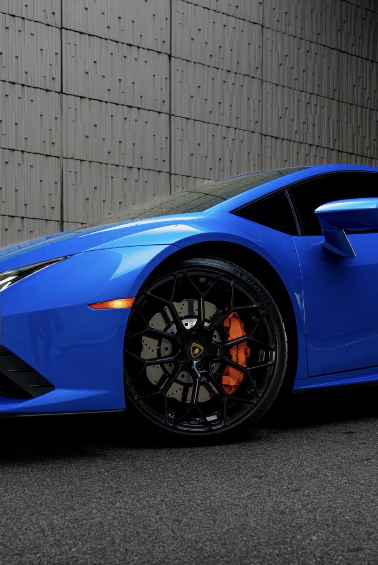 Front wheel and orange brake caliper of the Lamborghini Huracán Evo in Blu Eleos
