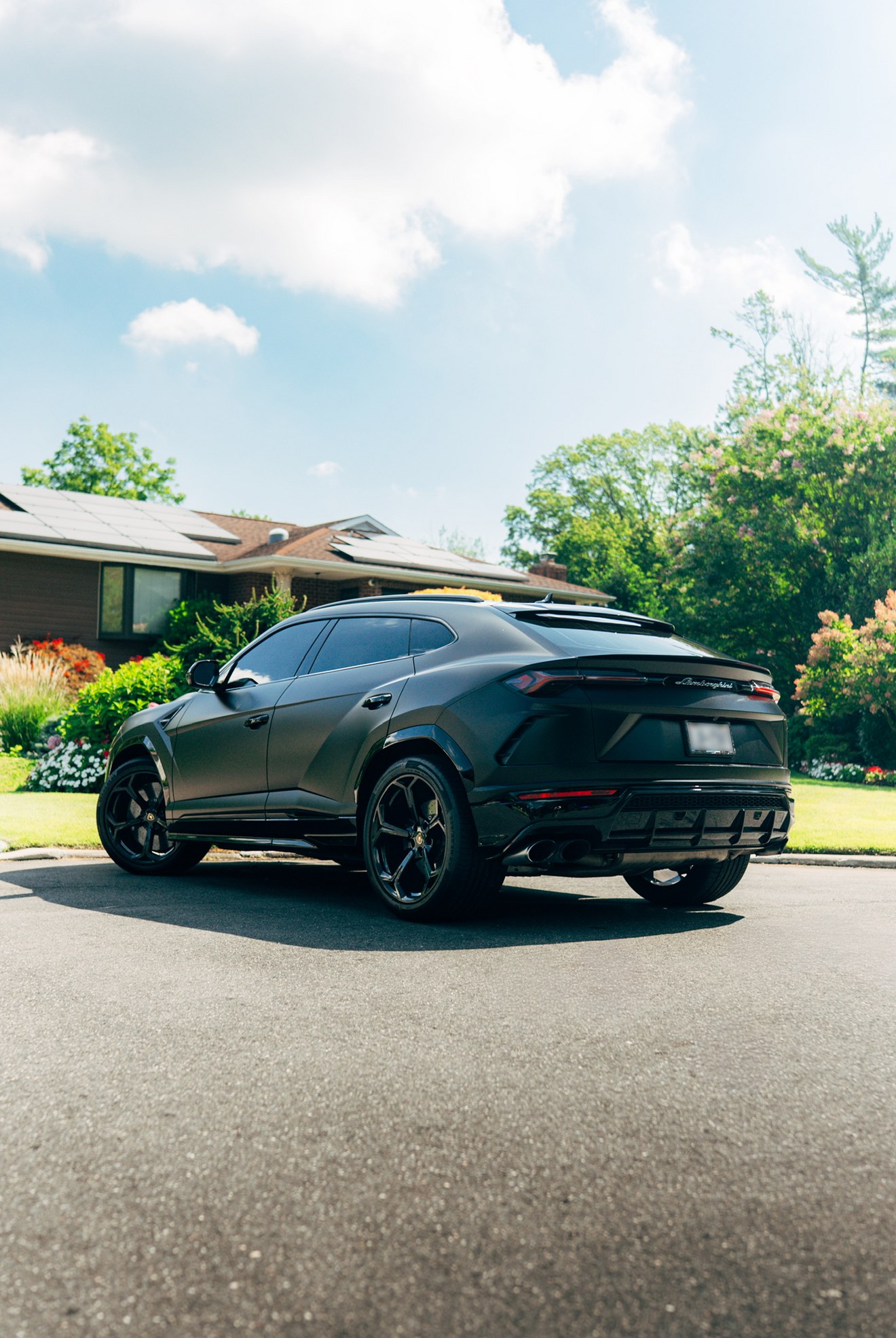 Matte black Lamborghini Urus shown from the rear three-quarter angle
