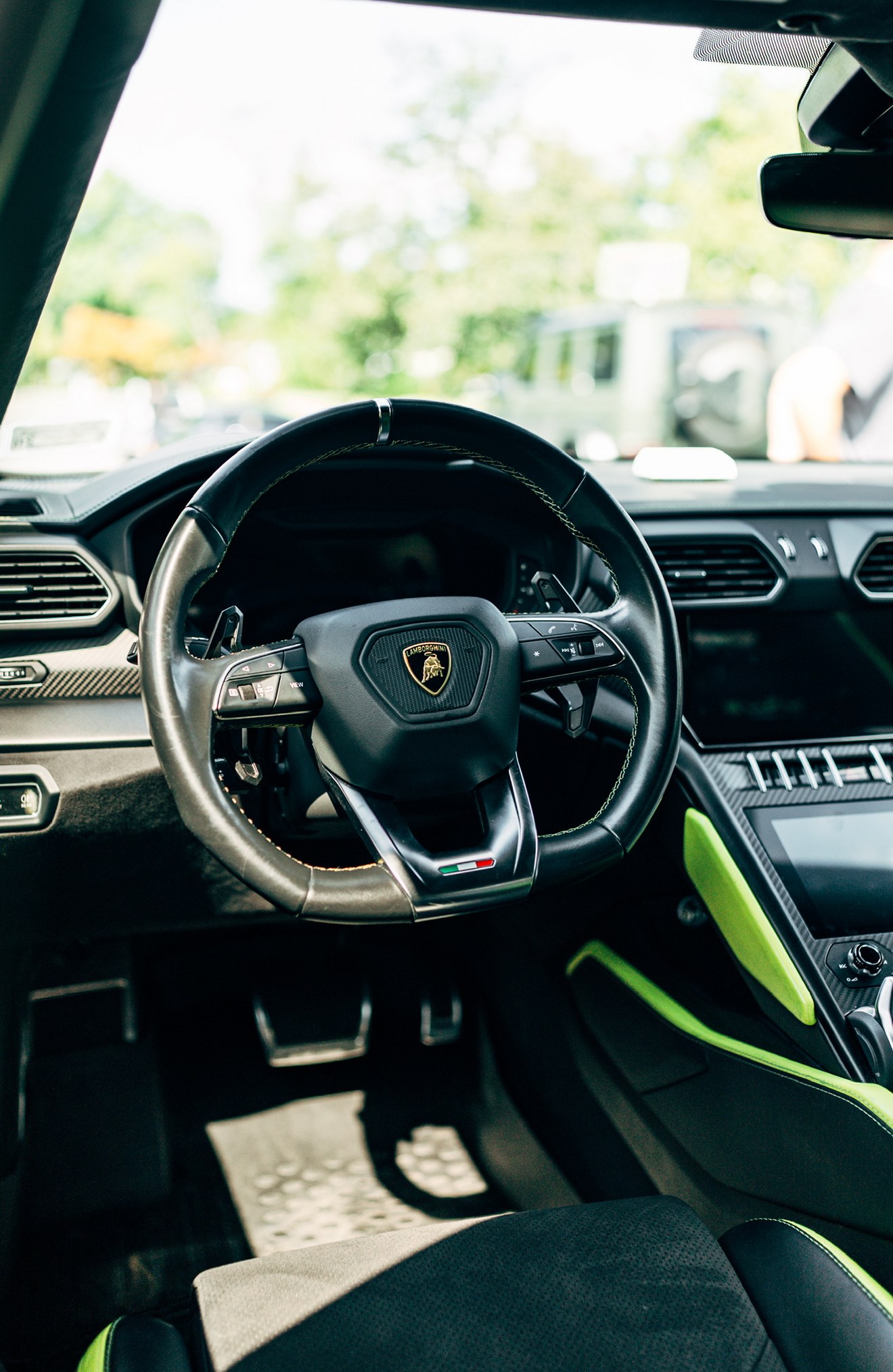 Steering wheel and center console with green accents in the Lamborghini Urus