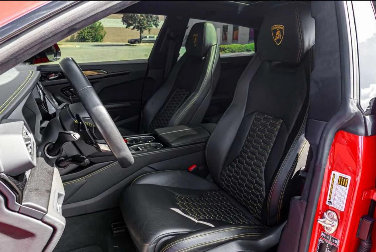 Black leather front seats with yellow stitching in the red Lamborghini Urus
