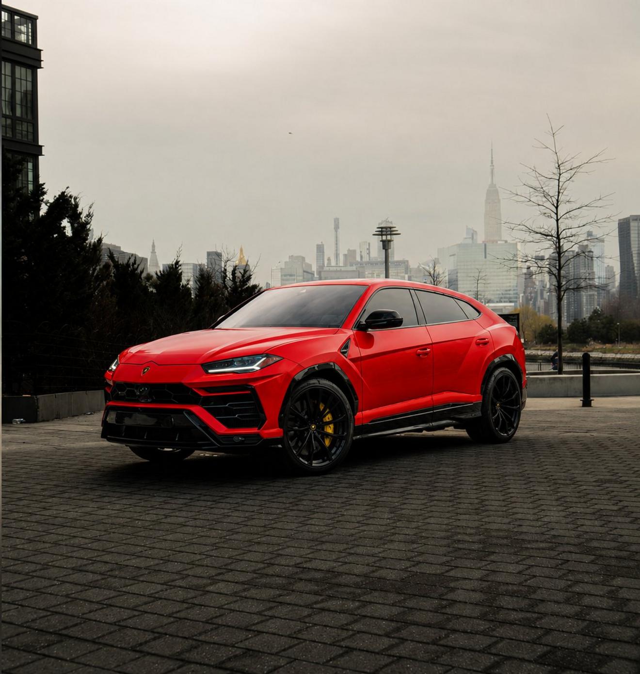 Red Lamborghini Urus shown from the front three-quarter angle with the Manhattan skyline