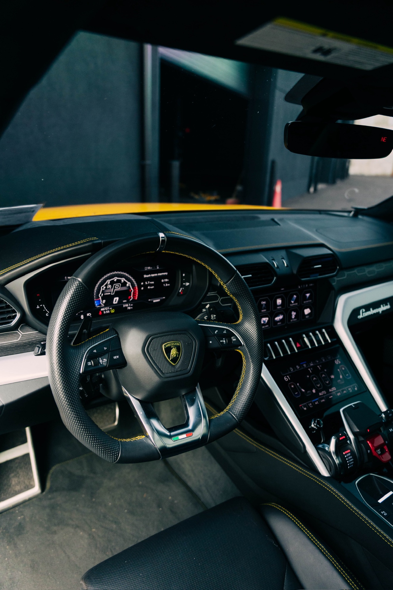 Driver cockpit of the yellow Lamborghini Urus with yellow contrast stitching