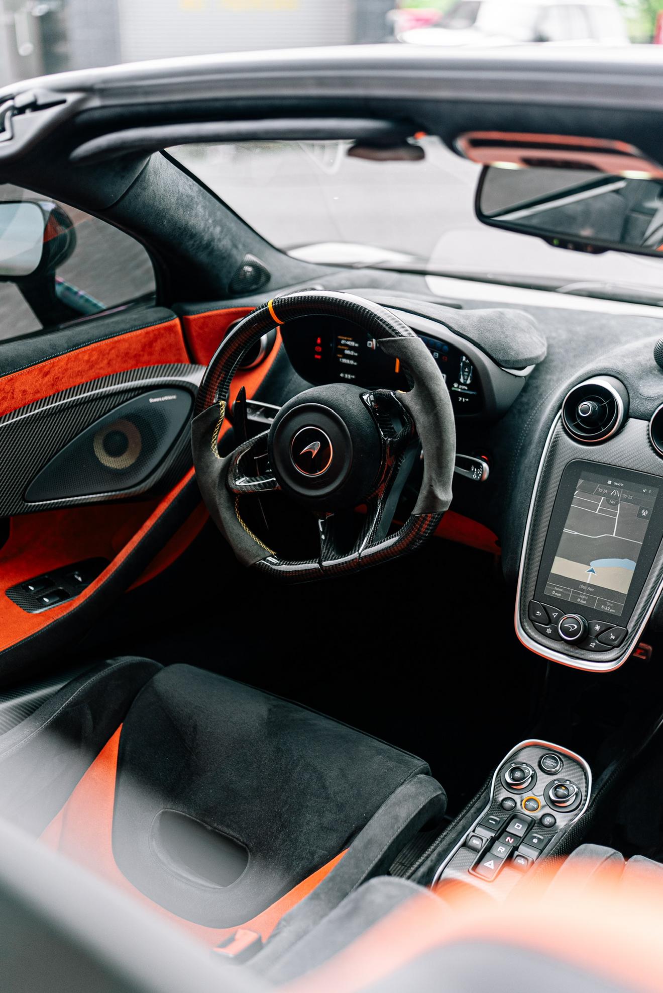 Driver cockpit of the McLaren 600LT with black and orange interior