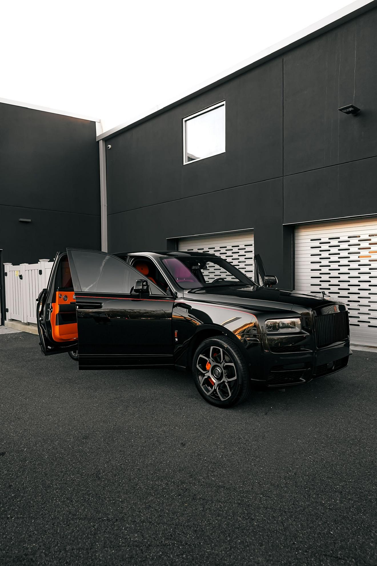 Black Rolls-Royce Cullinan shown from the front three-quarter angle with its doors open
