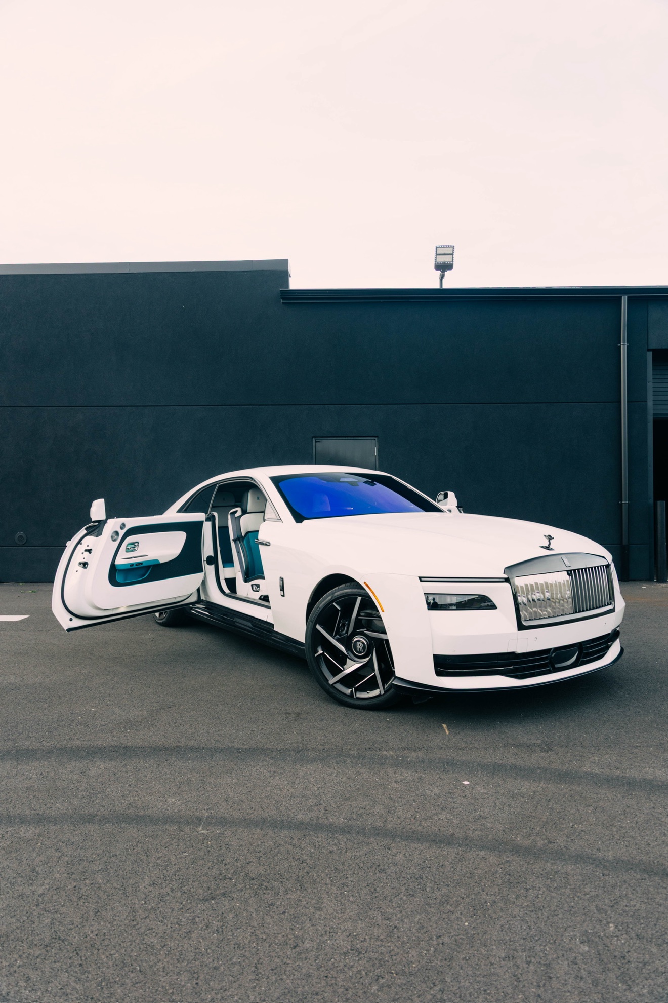 White Rolls-Royce Spectre shown from the front three-quarter angle with the doors open